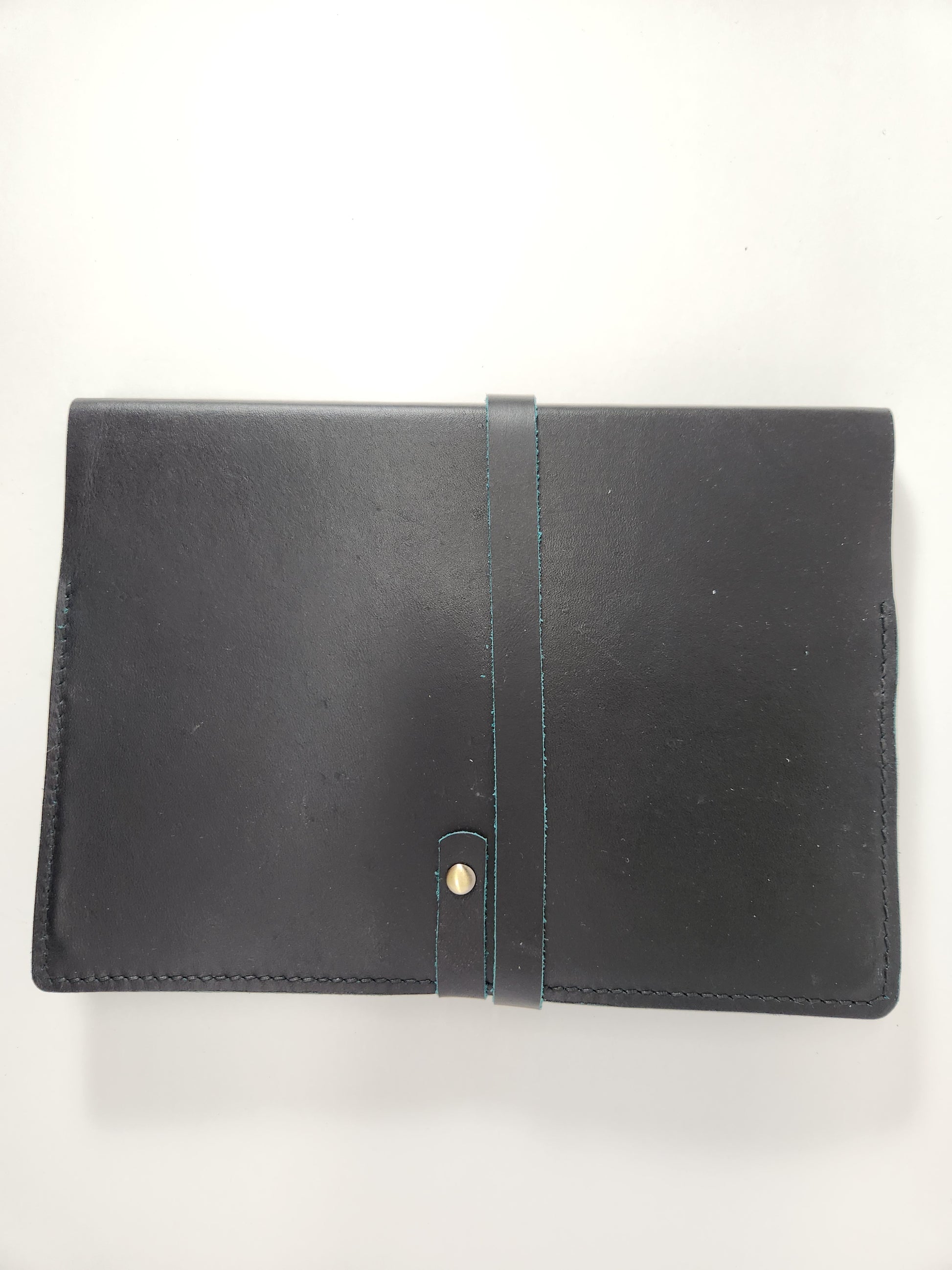 Handcrafted deep green leather journal cover with brass snap closure and hand saddle stitching